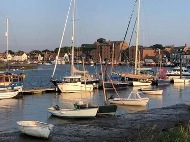 Fishing boats on Wells quay in golden evening light with the town behind